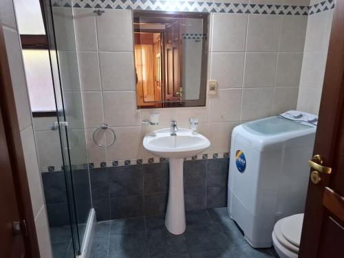 Un baño con lavabo, inodoro y espejo. en Casa en Piriápolis para ocho personas grande y luminosa, en Piriápolis