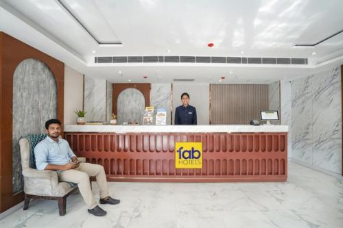 a man sitting in a chair in a hotel lobby at FabHotel Prime IP Indrapuram in Ghaziabad