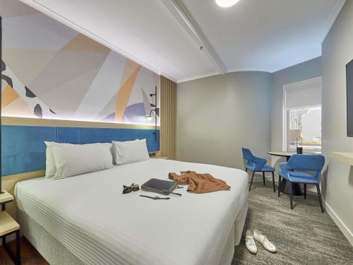 a bedroom with a bed with a laptop on it at ibis Perth in Perth