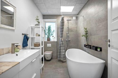 a bathroom with a large white tub and a toilet at FY258-Ebberup-Hegningen-5 in Ebberup