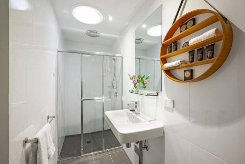 アデレードにあるNorth Adelaide Boutique Stays Accommodationの洗面台とシャワー付きの白いバスルーム