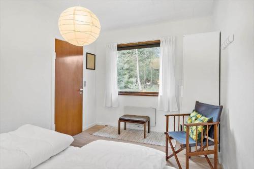 a bedroom with a bed and a chair and a window at FY358-Martofte-Sandvejen-3 in Martofte