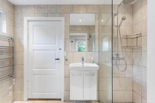 a bathroom with a white door and a sink and a shower at FY297-Faaborg-Ostergyden-37 in Faaborg