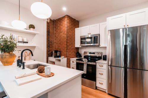 a kitchen with white cabinets and a stainless steel refrigerator at Sunny 2BR Apt with Kitchen & Parking, Near Brown & RISD in Providence