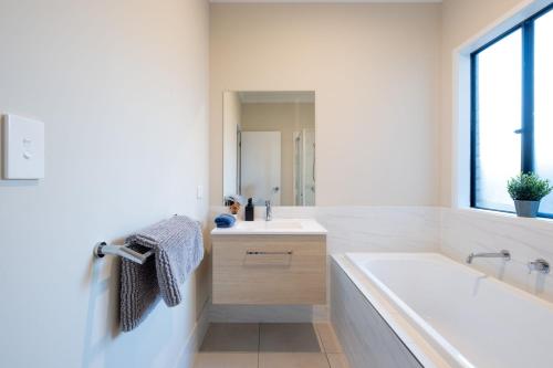 a white bathroom with a tub and a sink at Enchanting Griffin Retreat Memorable Stay Awaits in Griffin