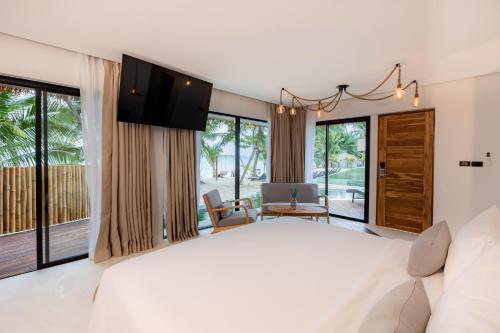 a bedroom with a large bed and large windows at Samaraya Wellness Resort in Amphoe Koh Samui