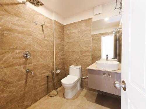 een badkamer met toilet, wastafel en douche bij Proximus - Boutique Hotel Apartments in Bangalore