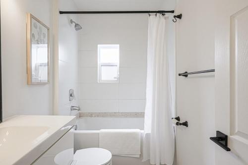 een witte badkamer met een bad en een toilet bij Cozy & Comfy house near Subway in Toronto