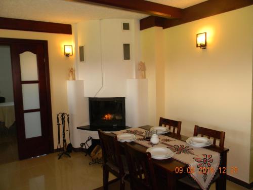 Un comedor con mesa y chimenea. en Szymkówka, en Nowa Biała