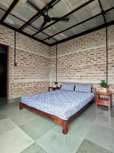 a bedroom with a bed in a brick wall at ZERO9 farmPAD - Private Eco Retreat, Karjat in Karjat