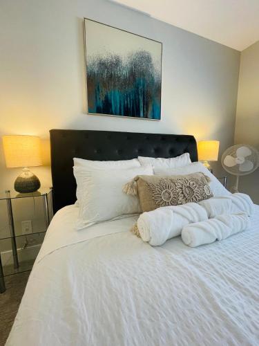 a bed with white sheets and pillows on it at Casa Del Mar-A family Suite in Victoria in Langford