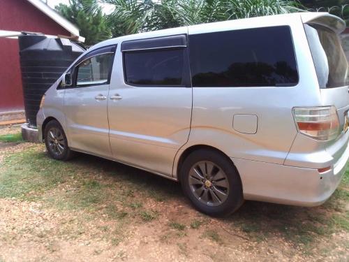 a white van parked in the grass next to a house at Victoria Stay in Jinja