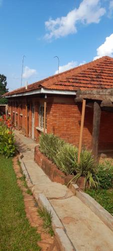 a red brick building with a pathway next to it at Miji Holiday Home in Jinja