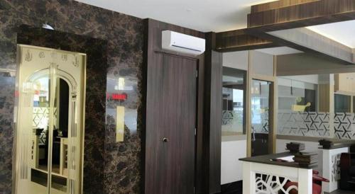 a kitchen with a door and a table in a room at Paragon Nagoya Hotel Batam in Jodoh