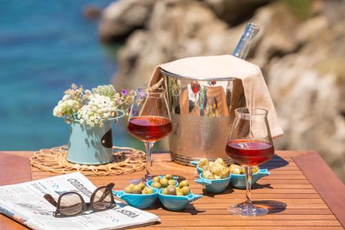 a table with two glasses of wine and snacks at Relais Regina Giovanna in Sorrento