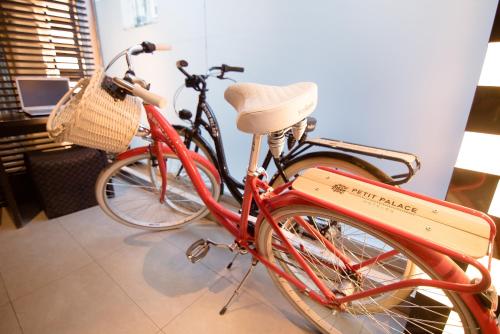 a red bike parked next to another bike with a basket at Petit Palace Cliper-Gran Vía in Madrid