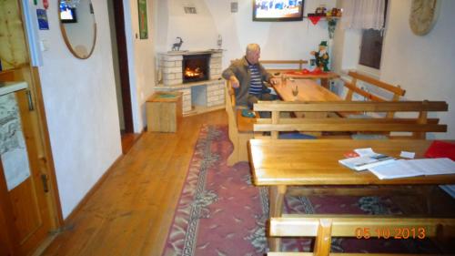 a man sitting at a table in a room with a fireplace at Penzion Dreveník in Spišské Podhradie