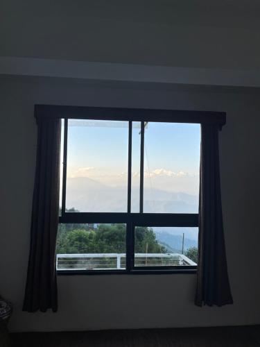 una ventana con vistas a las montañas en Degants pad, en Darjeeling