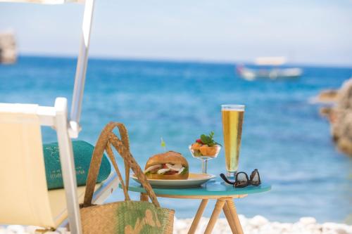 a table with a sandwich and glasses of champagne on the beach at Relais Regina Giovanna in Sorrento