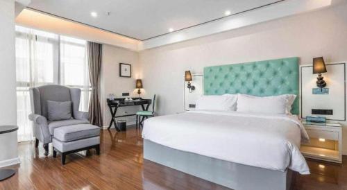a bedroom with a bed and a chair and a desk at Xana Lite Anqing Yuexi Swan Squre Branch in Yuexi