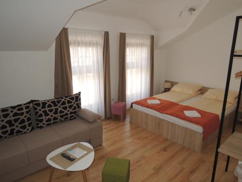 Hotel Logavina 8 Garage Parking في سراييفو: غرفة نوم صغيرة مع سرير وأريكة