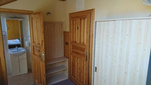 a bathroom with a sink and a wooden door at Penzion U Zvonku in Litvínov