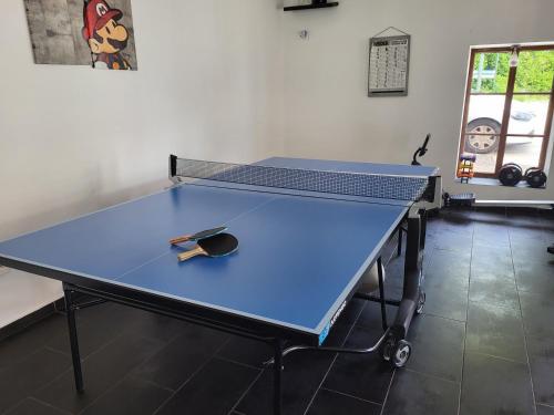 une table de ping-pong avec une raquette de tennis dessus dans l'établissement Aparthotel Des 2 Caps, à Ambleteuse