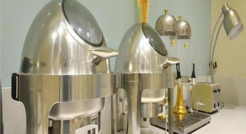 une cuisine avec un comptoir et 2 grands appareils en argent dans l'établissement City Comfort Inn Wuhan Xinzhou Mo'er Cheng, à Wuhan