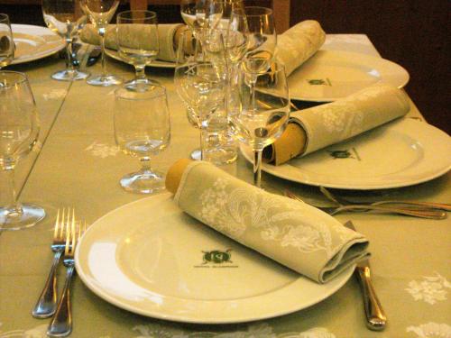 a table with plates and wine glasses on it at Albergo Scarpone in Forni Avoltri