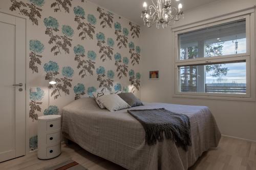 Un dormitorio con una cama y una ventana y una lámpara de araña. en Villa Mäntykumpu by Hi Ylläs, en Ylläsjärvi
