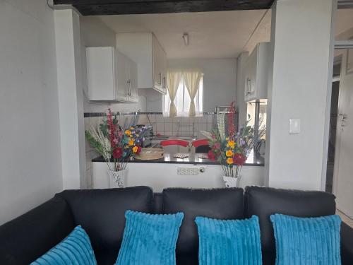 a living room with a couch and a kitchen at Wave Watcher in Amanzimtoti