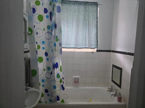a bathroom with a tub and a shower curtain at Wave Watcher in Amanzimtoti