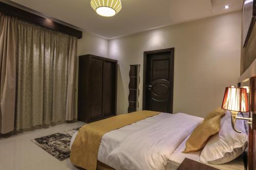 a bedroom with a large bed and a window at Al Itqan For Serviced Apartments-الاتقان للشقق المخدومة in Jeddah