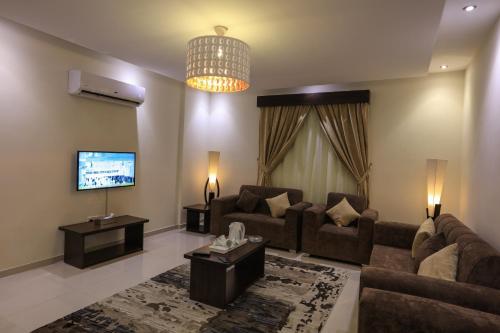 a living room with a couch and a tv at Al Itqan Apart-hotel in Jeddah