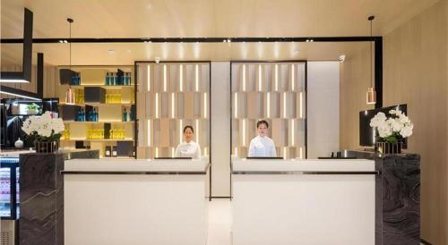 長沙市にあるEcharm Hotel Changsha Xiangya Fushanの部屋の鏡付きサロンの女性2名