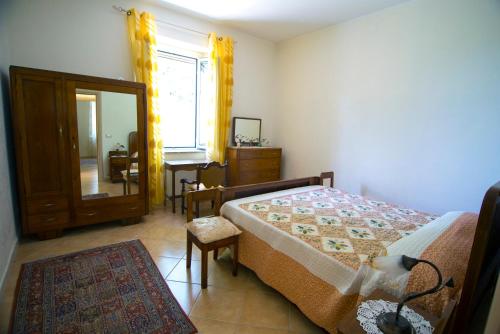 um quarto com uma cama, uma cómoda e um espelho em B&B CASA VACANZE Benvenuti al Sud em Aiello Calabro