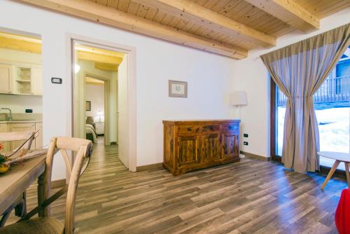 a living room with a table and a wooden floor at Borgo Fantino - Residenze e Alloggi Vacanza in Limone Piemonte