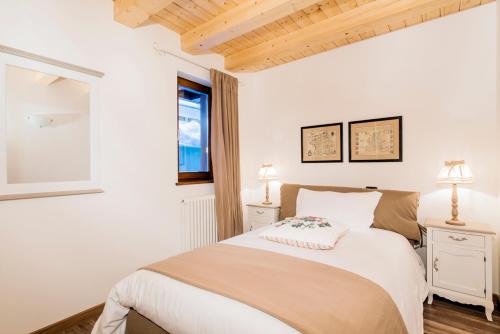 a white bedroom with a bed and a window at Borgo Fantino - Residenze e Alloggi Vacanza in Limone Piemonte