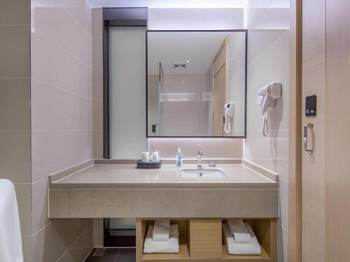 CangwuにあるCity Comfort Inn Wuzhou Xijiang Thrid Bridgeの洗面台と鏡のあるバスルーム