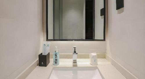 un lavabo de salle de bain avec deux brosses à dents et un miroir dans l'établissement City Comfort Inn Jiyuan Jishui Avenue Jigang, à Jiyuan