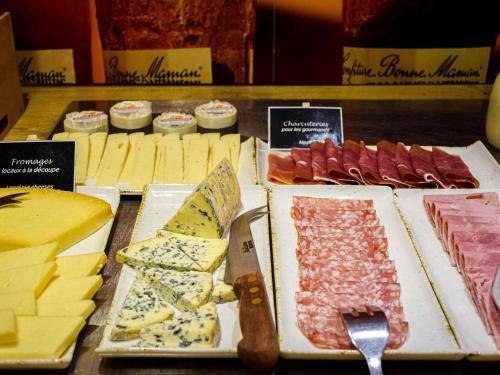 a display of different types of cheese and meats at ibis Rodez Centre in Rodez