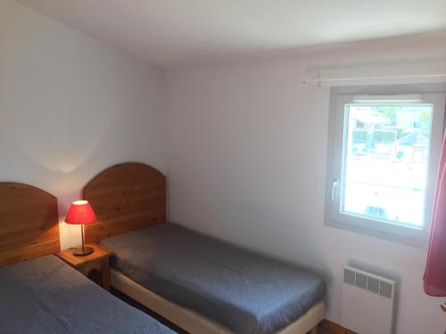 a bedroom with two beds and a window at Les sources de manon in Vallon-Pont-dʼArc