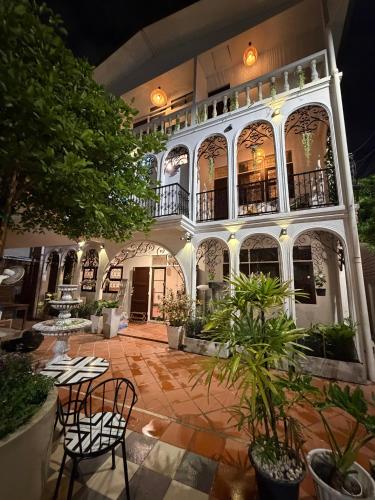 a large building with chairs and plants in a courtyard at Bangkok Neighborhouse - Guesthouse in Bangkok