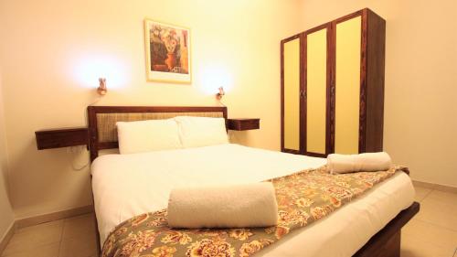 a bedroom with a bed with a wooden headboard at The Market Courtyard - Suites Hotel in Jerusalem