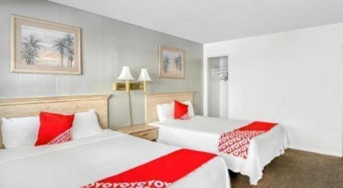 two beds in a hotel room with red and white pillows at OYO Gateway Motel Las Vegas North Strip/Fremont St. Area in Las Vegas