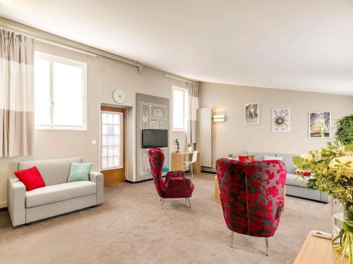 un salon avec un canapé et des chaises rouges dans l'établissement ibis Paris Grands Boulevards Opéra 9e, à Paris