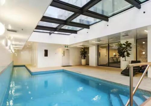 une grande piscine avec un grand plafond dans l'établissement Chic 2BR City Central Apt w Pool & Sauna & Gym, à Auckland