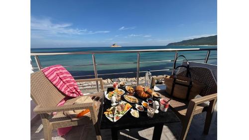 un plato de comida en una mesa en un balcón en Dream View Nova, en Rafrāf