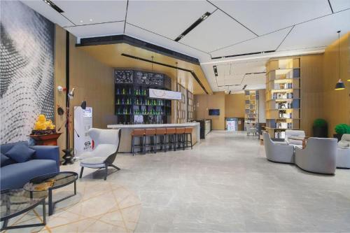 a lobby with chairs and a bar with wine bottles at Echarm Hotel Changsha Wuyi Square Xiangya Affiliated 1st Provincial Maternity and Child in Changsha