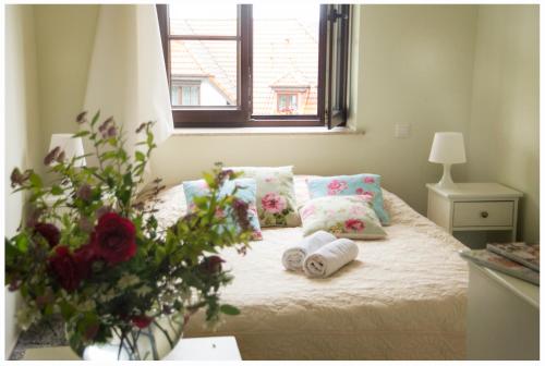 a bedroom with a bed with towels and a vase of flowers at Willa Pod Basztą Restauracja&Wellness in Kazimierz Dolny